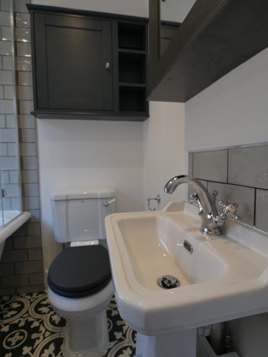 Traditional bathroom with roll-top bath and patterned floor tiles